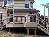 <b>Composite Deck with tan vinyl railing with matching cocktail rail and black ballusters and 2 tan pergolas</b>